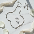 Luxury white gold jewelry set flat lay on white marble